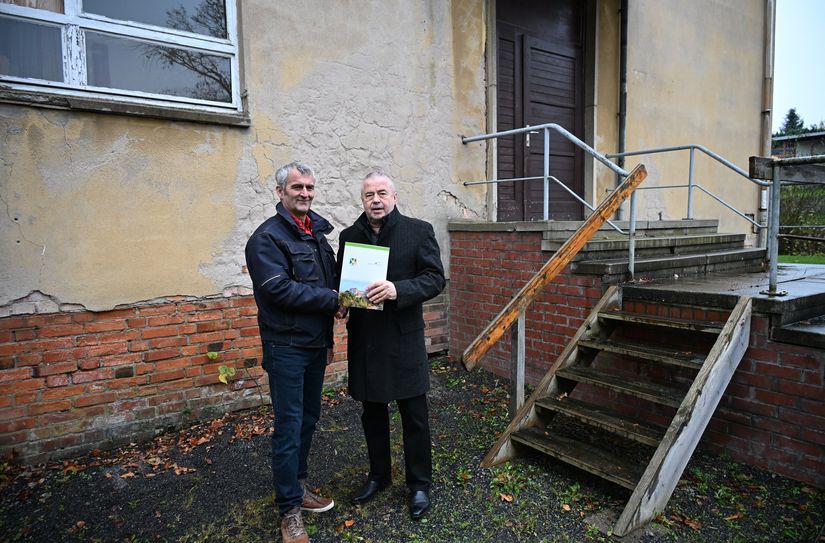 Struppens Bürgermeister Michael Sachse und Landrat Michael Geisler (re.) vor der Alten Schule.