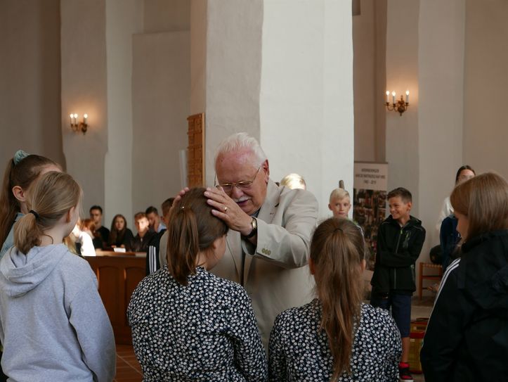 Superintendent i.R. Friedhart Vogel segnet Schüler beim Eröffnungsgottesdienst.