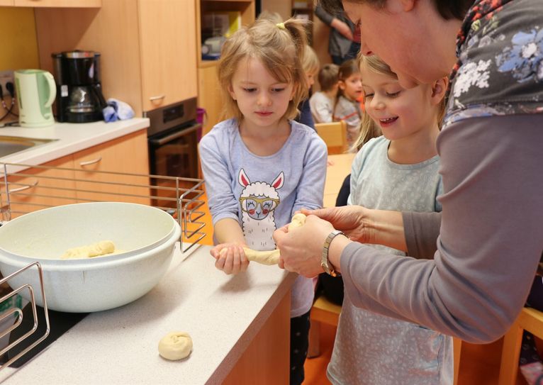 Elsa und Johanna backen in der neuen Kinderküche kleine Hefeteig-Vögelchen.