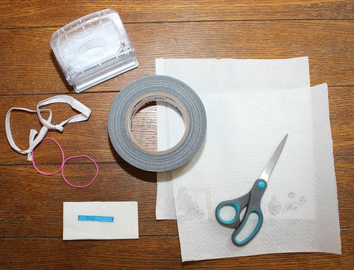Für den Mundschutz Marke Eigenbau braucht man Schere und Locher, breites Klebeband, vier Gummis, einen Draht, ein Taschentuch und zwei Lagen Küchenrolle. Foto: Keil