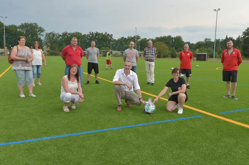 Katja Beuthan (rechts vorne), Vorsitzende des Senftenberger FC 08, eröffnet gemeinsam mit Bürgermeister Andreas Fredrich (Mitte) den Kunstrasenplatz.