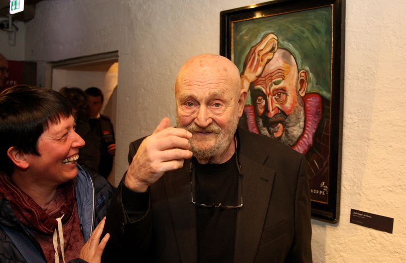 Rolf Hoppe in der Sonderausstellung auf Weesenstein vor einm Porträt von ihm.