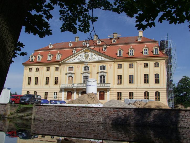 Das im 18. Jahrhundert im Stil des Dresdner Barock errichtete Schlossgebäude liegt auf einer von einem Wassergraben umgebenen, knapp 3.400 Quadratmeter großen Insel.