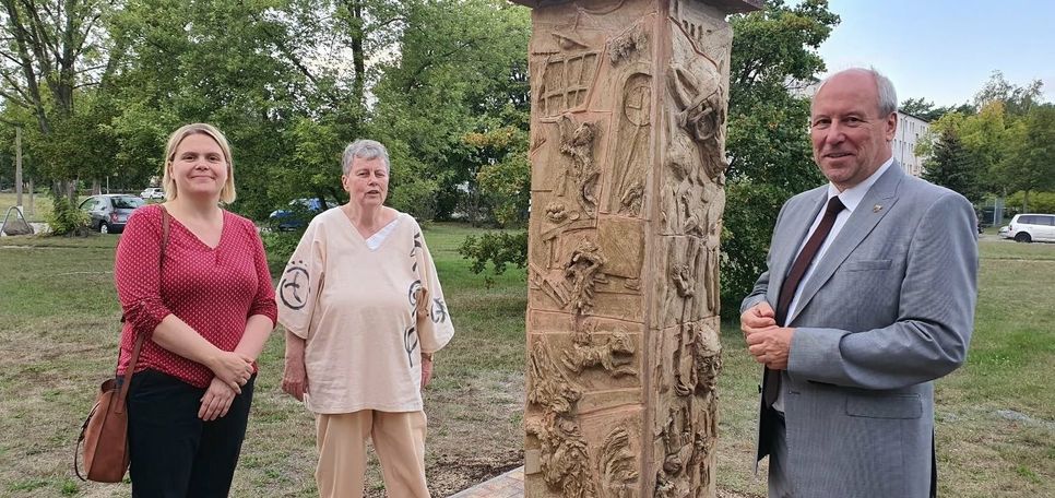 Mitarbeiterin der Lebenshilfe Werkstätten Frau Nitschke, Künstlerin Frau Noack begutachteten gemeinsam mit Bürger-meister Fred Mahro den neuen Standort der Märchenstele.