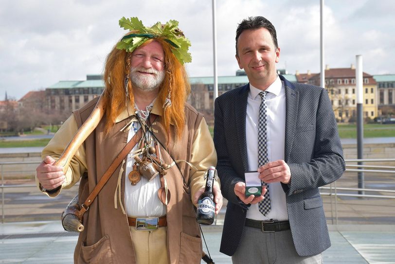 Riesas Oberbürgermeister Marco Müller präsentiert die Festmedaille zum Tag der Sachsen und das Stadtmaskottchen, der Riesaer Riese, empfiehlt ein Bier speziell zum Fest im Landtag in Dresden. Foto: Trache
