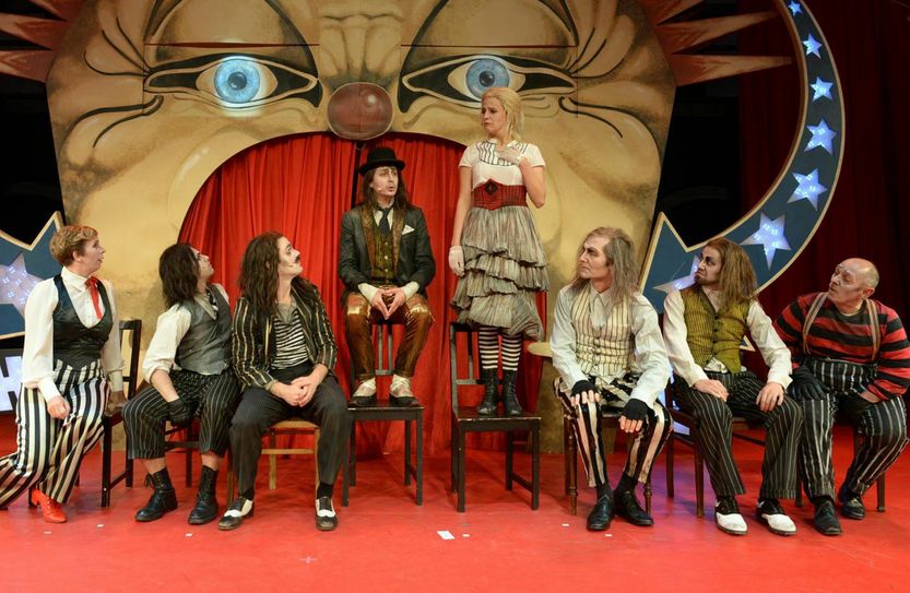 Aline Bucher als Polly Peachum (Mitte, stehend) und Tom Bartels als Mackie Messer (Mitte, auf der Stuhllehne sitzend), sorgen mit ihrer heimlichen Heirat für ein großes Wirrwarr in der Londoner Unterwelt. Foto: Theater »neue Bühne Senftenberg«
