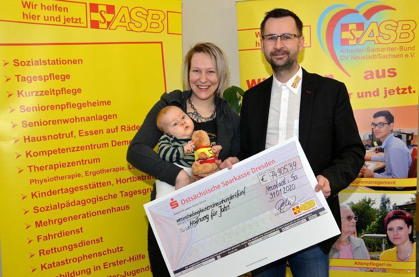 Frau Brandt und John erhalten im ASB-Haus in Neustadt/Sa. den (im wahrsten Sinne des Wortes) riesigen Scheck von Herrn Penther. Foto: PR