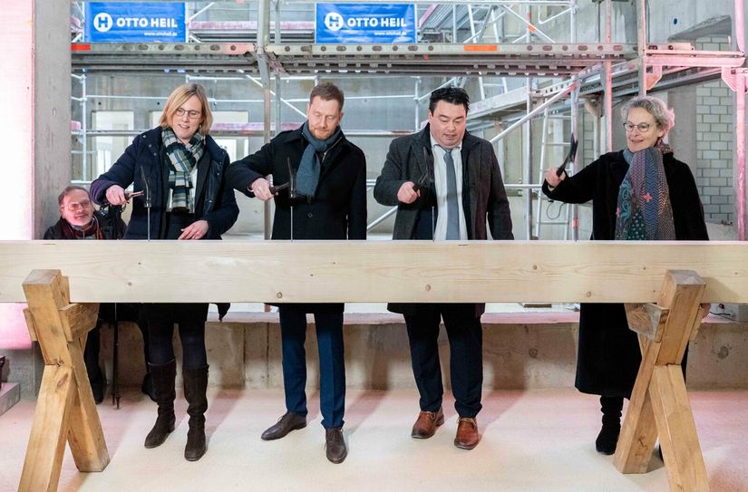 Prof. Esther Troost (Dekanin der Medizinischen Fakultät), Ministerpräsident Michael Kretschmer, Frank Ohi (Kaufm. Vorstand des Dresdner Uniklinikums) und Prof. Ursula Staudinger (Rektorin der TU Dresden) schlagen die Nägel in den symbolischen Balken.