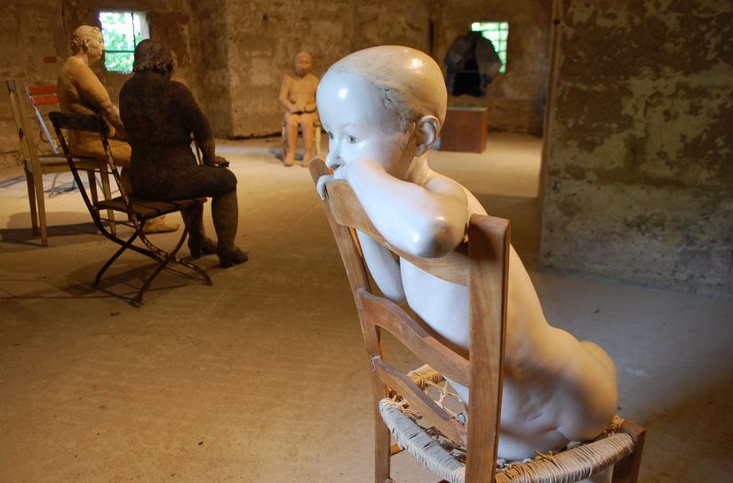»Sitzendes Mädchen« von Christa Biederbick vor der Sitzgruppe von Hana Purkrabkova im Ausstellungsraum Dritter Turm des Skulpturensommers.