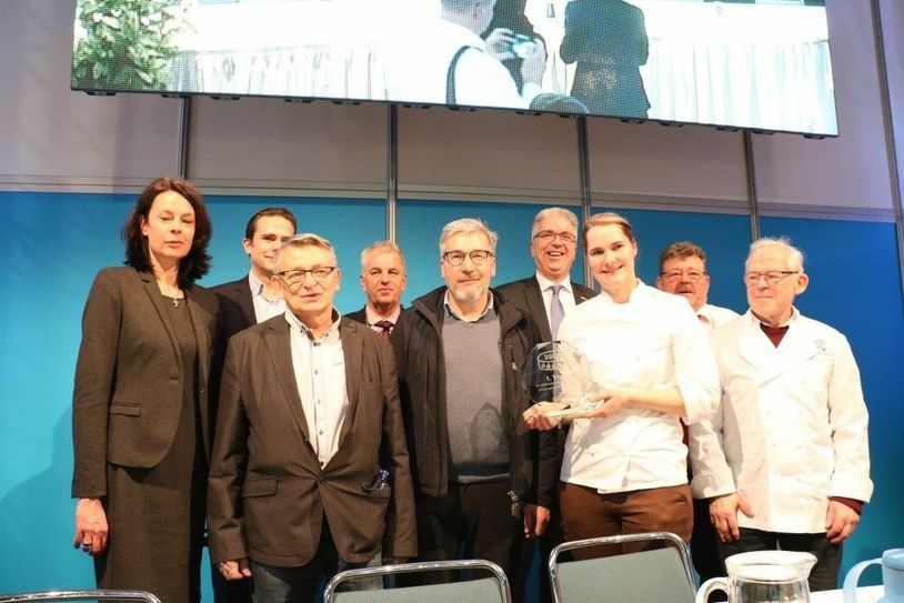 Freut sich über den 1. Platz im Wettbewerb »Jubiläumstorten«: Konditormeisterin Elisabeth Anders (mit Pokal). Juryvertreter und Vertreter der weiteren Podestplätze sowie Ehrenobermeister Hartmut Spaethe (re.) umrahmen die 29-Jährige. Foto: Bäckerei Anders