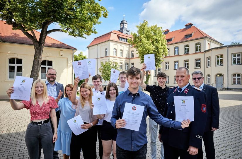 Sieben Schüler bekamen die Urkunde Truppmann Teil 1 von Christian Piwarz (2.v.li.) und Wehrleiter Karsten Hose (2.v.re.) von der FFW Borthen-Röhrsdorf. Mitte vorn: Adrian Preuß (16) möchte bei der Feuerwehr bleiben und aktiv mitmachen. Außerdem im Bild: Schulleiterin Antje Ambos (3.v.li.) und Dohnas Bürgermeister Dr. Ralf Müller (re.).
