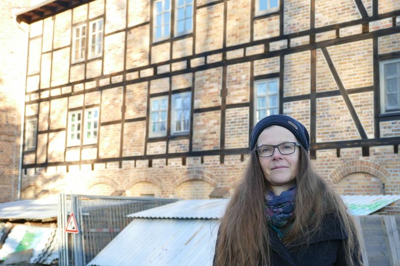 Nancy Sauer vor der Alten Ziegelei. Noch ist Baustelle sichtbar, doch der Einweihungstermin steht fest. Foto: Jost Schmidtchen