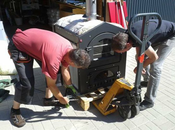 Viele fleißige Hände helfen bei der Montage des Ofens.