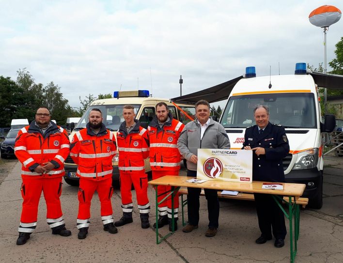 Am 15. Juli 2019 unterzeichneten Peter Rublack (rechts), Vorsitzender des Kreisfeuerwehrverbandes (KFV) Dahme-Spreewald e.V. und Andreas Berger-Winkler (2.v.r.), Regionalvorstand des Johanniter-Unfall-Hilfe e.V., Regionalverband Südbrandenburg, am Standort der Katastrophenschutzeinheit der Johanniter in Lübben eine Vereinbarung zur gegenseitigen Partnerschaft. Foto: Johanniter