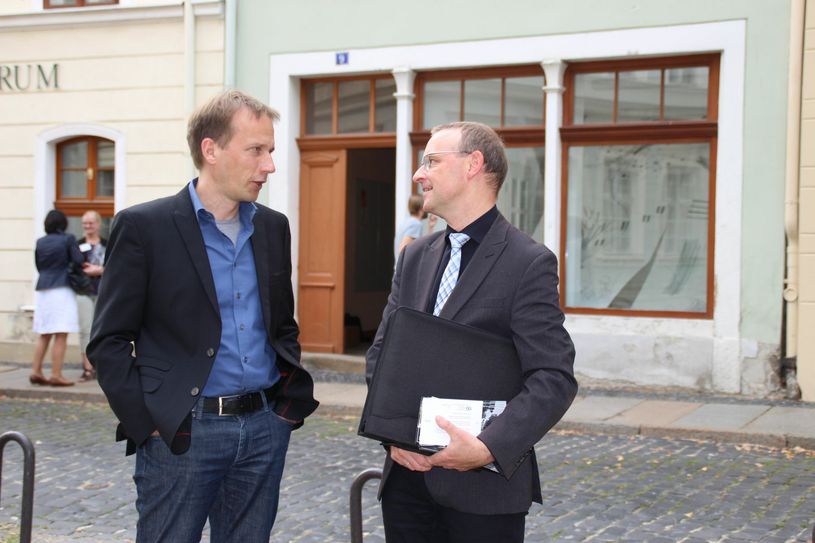 Prof. Dr. Robert Knippschild, Leiter des IZS, und Hartmut Wilke (rechts), Leiter des Amtes für Stadtentwicklung bei der Stadt Görlitz, vor dem Ideenlabor „Neun Görlitz“ (Fischmarkt 9) des Wildwuchs e. V., einen der Arbeitsräume die für das Projekt zur Verfügung stehen. Foto: Keil
