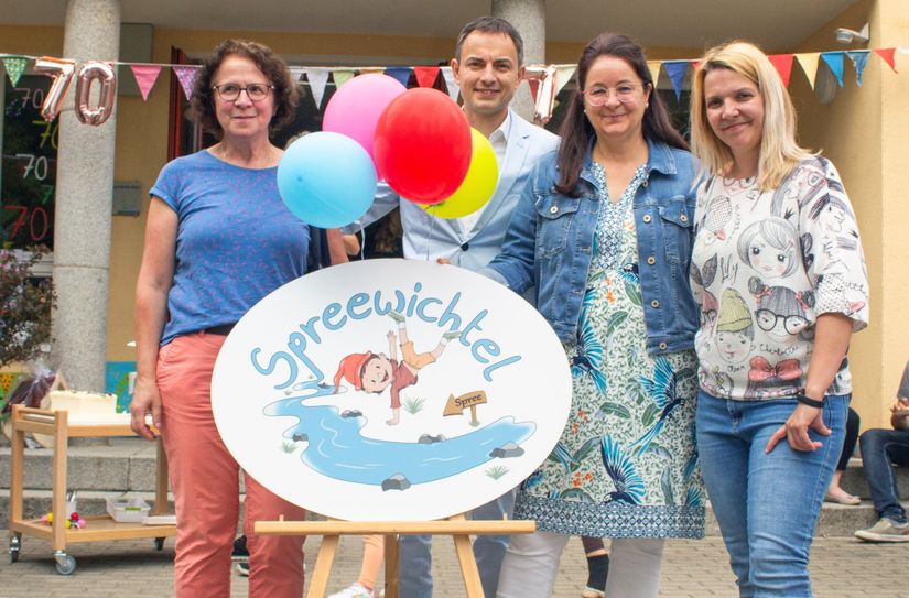 Ines Schöbel, Thomas Groß und Ilka Heilmann vom Amt für Bildung und Soziales sowie Kita-Leiterin Claudia Günther bei der Enthüllung des neuen Kita-Namens "Spreewichtel".