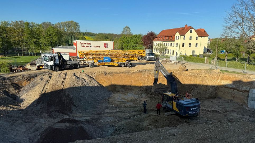 Die Baugrube ist Ende April 2025 fast fertig und der Baukran rollte an.