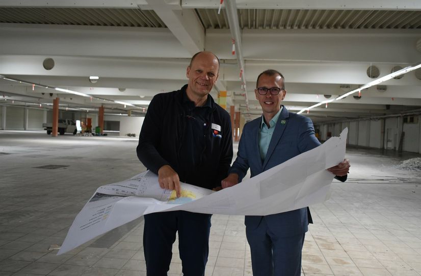 Peter Simmel und der Bürgermeister von Bannewitz, Heiko Wersig (parteilos), bei der Begutachtung des Bauplanes für den zukünftigen Simmel-Markt.