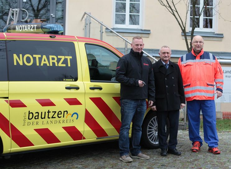 Ordnungsamstleiter Rene Burk (Mitte) übergibt das Notarzteinsatzfahrzeug an  die Falck Notfallrettung und Krankentransport GmbH Hamburg und den Standortleiter Oberarzt Dr. Tilo Driesnack (r.).