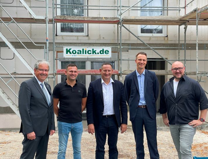 Landrat Harald Altekrüger, die Bauherren Sandro und Torsten Koalick, Jan Muschka, Direktor Firmenkunden Sparkasse Spree-Neisse, Bauunternehmer Christof Lehmann (v.l.n.r.) auf der Baustelle des Wohnungsbau-Projekts im Schlosspark Raakow.