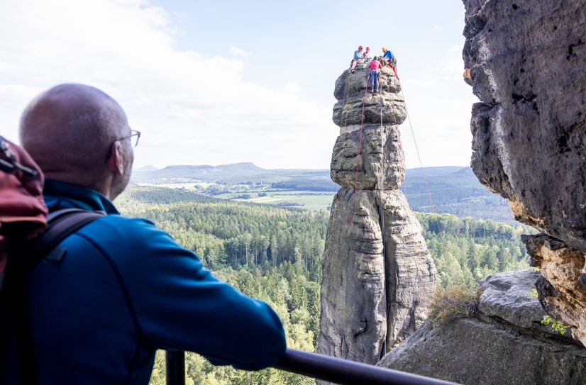 Kletterer erklimmen die Felsnadel zu Kontrollzwecken.