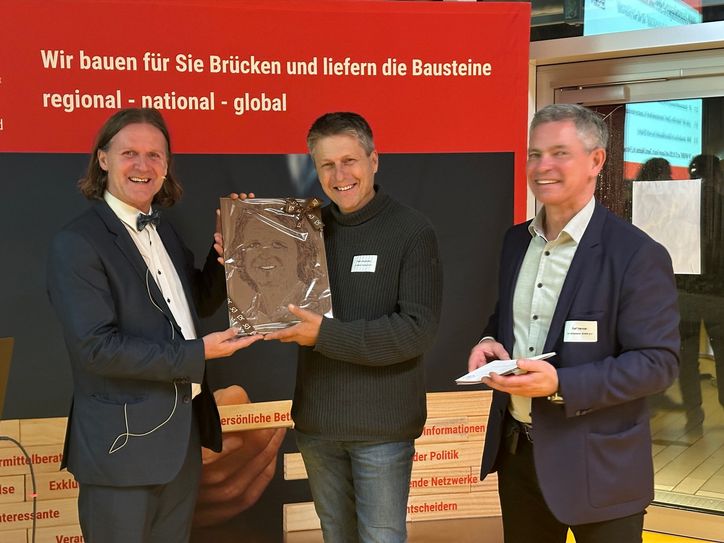 Sorgte für große Überraschung beim Referenten: Ralf Henkler (re.) vom BVMW und Peter Bienstmann (Mitte), Chocolaterie Felicitas, überreichten Timo Leukefeld sein eigenes Porträt aus Schokolade.