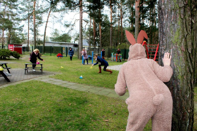 Corona macht, trotz vieler negativer Schlagzeilen, auch erfinderisch. Die Erzieherinnen der VdK - Kita „Regenbogen“ staunen über die Osterkörbchen, die sie den Kita – Kindern nach Hause bringen. Der „Osterhase“ beobachtet das bunte Treiben aus sicherer Entfernung. Foto: Silke Richter