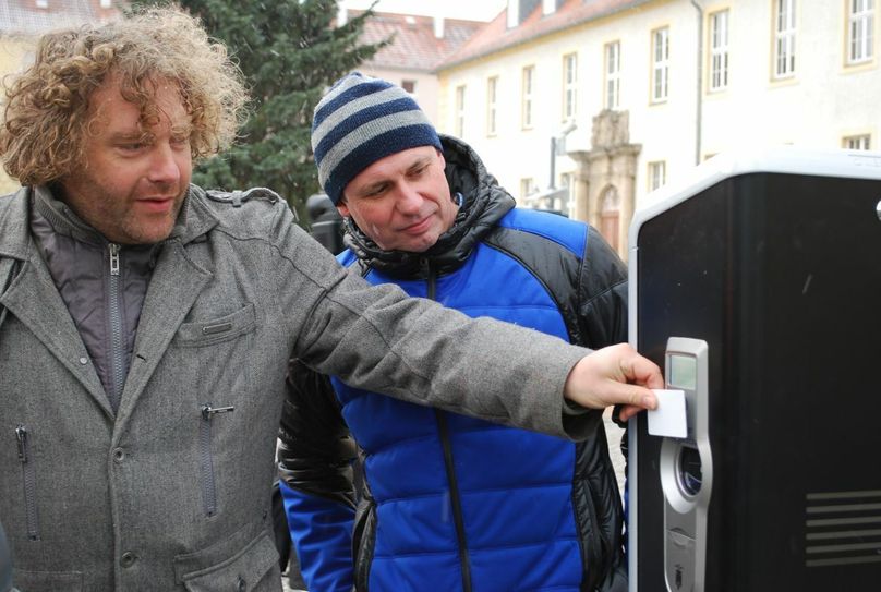 René Marko (rechts) von den Stadtwerken und Torsten Pötzsch an der neuen Elektrotankstelle am Marktplatz. Die funktioniert über eine Chipkarte, die man entweder beim Kauf des Fahrzeugs bekommt oder bei den Stadtwerken erhält.	Foto: Keil
