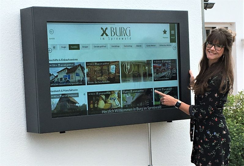 Die Mitarbeiterin der Touristinformation Marie-Luise Meinert führt den neuen digitalen Infopunkt am Haus des Gastes vor. Foto: HdG
