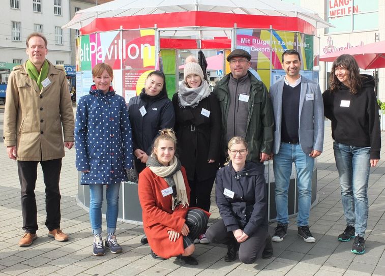 WeltPavillon Präsenzteam am 17.September auf dem Stadthallenvorplatz in Cottbus. Grit Bartels, Integrationsbeauftragte der Stadt Cottbus (2. v.l.). In der Mitte: MiA (3.-5. v. l.), JMD (6. und 7. v.l.) und IQ. (8. v.l.), und die Initiatoren des WeltPavillon-Projekts (1. und 9. v. l).