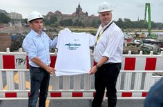 OB Dirk Hilbert übergibt Thomas Alscher, Geschäftsführer der Hentschke Bau GmbH, ein spezielles Carolabrücke-T-Shirt.