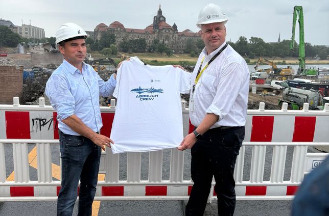 OB Dirk Hilbert übergibt Thomas Alscher, Geschäftsführer der Hentschke Bau GmbH, ein spezielles Carolabrücke-T-Shirt.