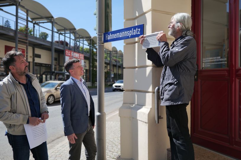 Christian Friedel, Amt für Stadtmarketing, Tourismus und Kultur, Bürgermeister Markus Renner und Dr. Helge Landmann beim Anbringen des Schildes.