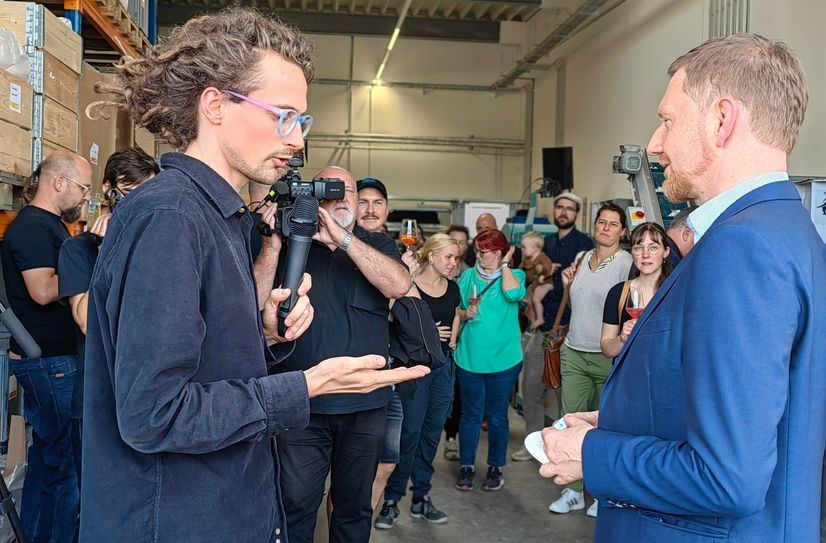 Ministerpräsident Michael Kretschmer kam zur Eröffnung der neuen Halle an der Freiberger Straße 112. In der Hand hält er einen Rauchmelder - Kunststoffteile, die komplett nicht wiederverwendet werden.