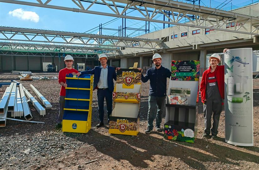 Azubi Tristan, GF Stephan Ellerhold, GF Maximilian Ellerhold und Azubi Anne (v.l.) mit einigen ihrer Produkte mitten im Rohbau der neuen Halle.