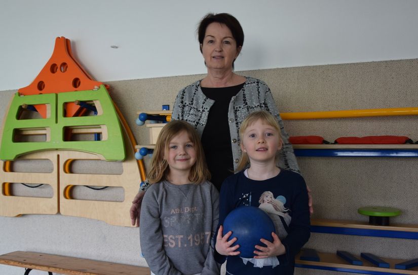 Andrea Smilowsky steht mit zwei ihrer Schützlinge im Sportraum.