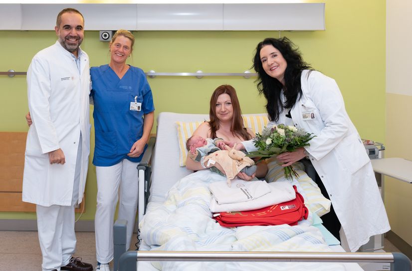 Prof. Cahit Birdir, leitender Oberarzt im Kreißsaal (l.), Schwester Jana (2.v.l.) und Prof. Pauline Wimberger, Direktorin der Klinik für Frauenheilkunde und Geburtshilfe, gratulieren Mama Isabell.