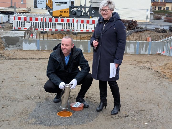 Grundsteinlegung für den neuen Hort: Bürgermeister Sebastian Hein und Romy Reinisch, Beigeordnete des Landrats, versenken die Zeitkapsel im Boden.