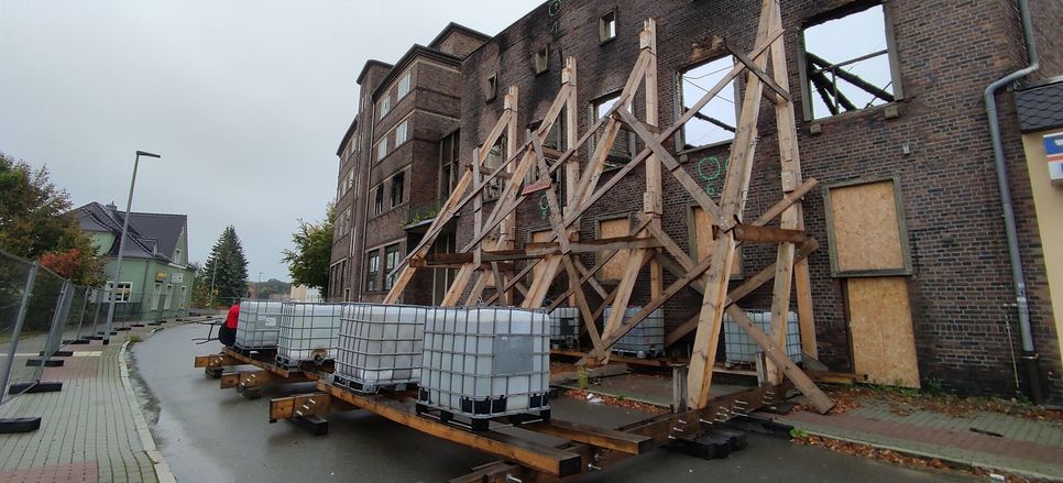 Die Holzstützen müssen weg und der Gebäudeteil anders gesichert werden, damit die Straße wieder freigegeben werden kann.  Foto: T. Keil