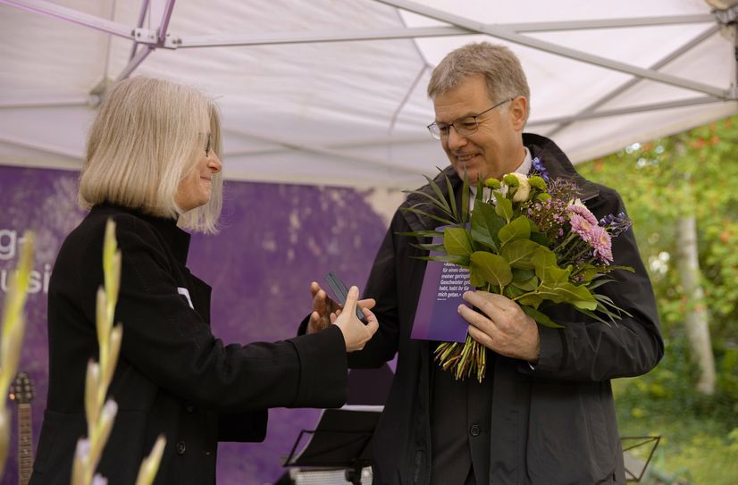 Ulrike Menzel, Vorsitzende des Diakonischen Rates des DWB, überreicht Rektor Markus Müller die Wichern-Plakette.
