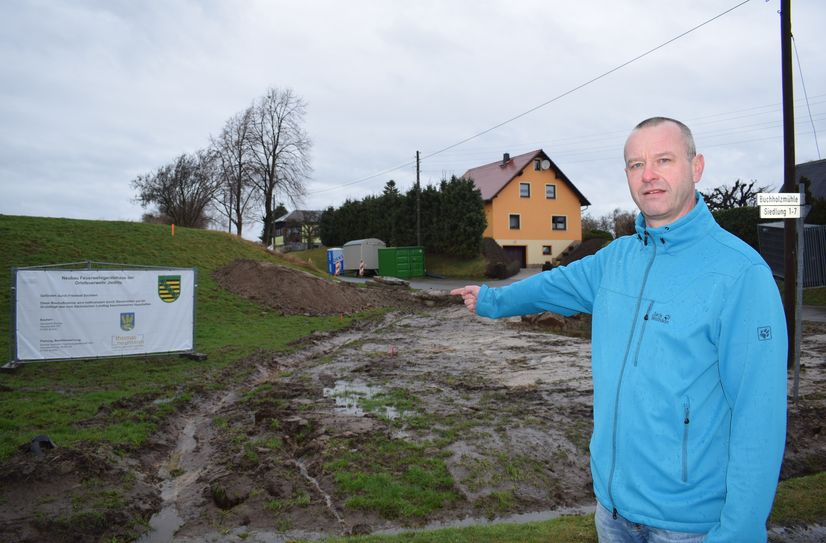 Bürgermeister Sebastian Hein zeigt auf das Grundstück in Jiedlitz, wo das neue Gerätehaus gebaut werden soll. Die Bauarbeiten haben am 12. Februar begonnen.