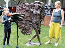 Jolina Große begleitet die Doberluger Künstlerin Catrin Große, hier nebeneiner  ihrer Monumentalplastiken, auf der Violine.