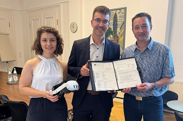 Christoph Koban erhielt von Jörg Szewcyk und Schulamtsmitarbeiterin Laura Seiffert den bewilligten Fördermittelbescheid für das BSZ Kamenz. Laura Seiffert brachte zudem eine VR-Brille mit, die - mit weiteren Exemplaren - künftig ebenfalls am BSZ zum Einsatz kommen wird.
