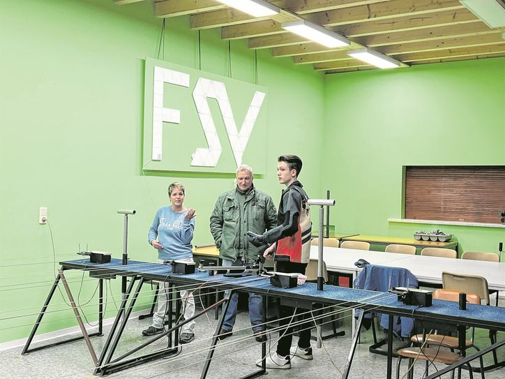 Übungsleiterin Daniela Gräßel (l.) und Vereinsvorsitzender Steffen Jentsch (m.) erklären potenziellen Jungschützen zuallererst die Technik und den sicheren Umgang mit den Sportgeräten am Schießstand.