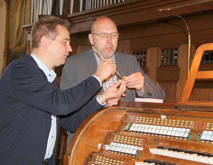 Orgelbauer Ralf Jehmlich und Oberbürgermeister Olaf Raschke befestigen das fertig bemalte Porzellanschild  an der neuen Registerwippe der sanierten Orgel der Frauenkirche in Meißen. Hoffentlich kann durch die neue Wippe bald die geplante Porzellanorgel zum Klingen gebracht werden. Fotos: Farrar