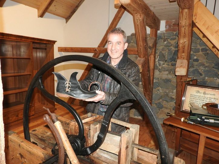 Lutz Lietze mit seinem "Wunderschuh" inmitten historischer Gerätschaften.