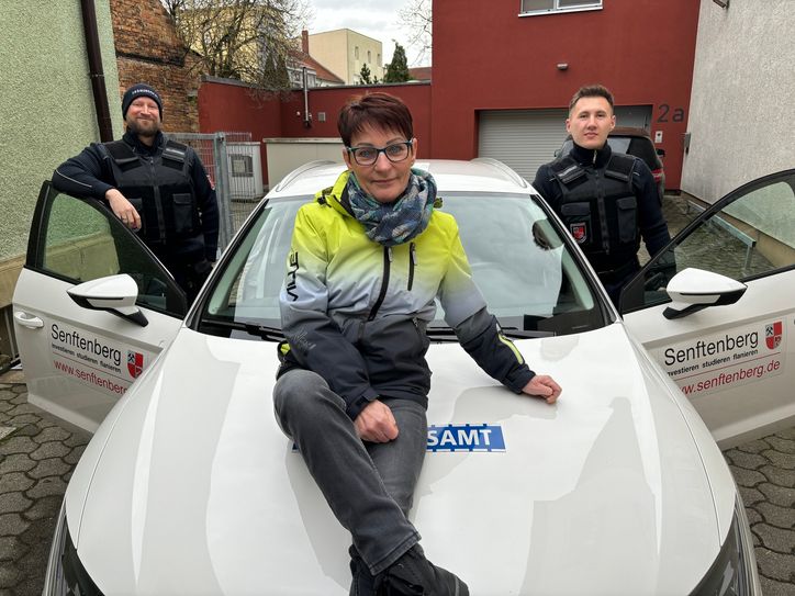 Mit dem weißen Dienstauto war Marina Tietze viel unterwegs. Wenngleich sie durchs Stadtgebiet am liebsten zu Fuß patrouillierte. Zum Abschied nahmen Sachgebietsleiter Tillmann Bartz (r.) und ihr Nachfolger Torsten Manthey ihre Kollegin nochmal in die Mitte.
