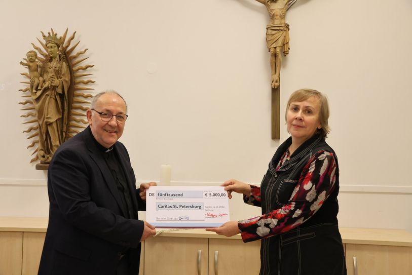 Bischof Wolfgang Ipolt und Natalia Pewzowa, Direktorin der Caritas St. Petersburg, bei der Übergabe der Spende.