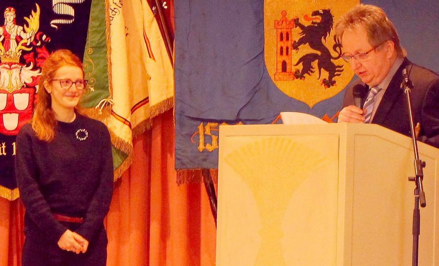 Ruth Trommer, Preisträgerin des Ausbildungspreises 2017, hört der Beurteilung ihrer Leistung – vorgetragen von Kreishandwerksmeister Peter Liebe – zu.