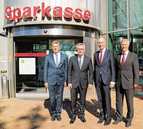 Meißner Landrat Arndt Steinbach, Innenminister Dr. Thomas de Maiziere, Vorstandsvorsitzender Rolf Schlagloth und Vorstand Rainer Schikatzki (v.l.) vor dem Sparkassen Hauptsitz in Riesa.  Foto: PM